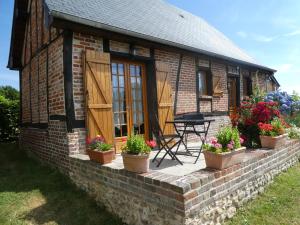 L'Etape Normande في Montroty: منزل من الطوب مع نباتات الفخار أمامه