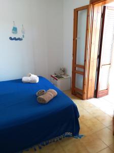 Un dormitorio con una cama azul con toallas. en Camera Torre Dell'Orso en Torre dell'Orso