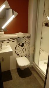 a bathroom with a toilet and a sink at ibis budget Dieppe Centre Port in Dieppe