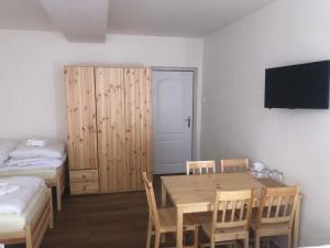 Pokój ze stołem oraz sypialnią z łóżkiem i telewizorem w obiekcie Penzion Hvězda - Restaurace dočasně uzavřena w mieście Rumburk
