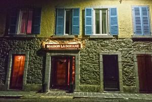 un edificio con un cartel que lee Malcom islandalling en Maison La Douane - Comprends nettoyage professionnel et le linge, en Laruns