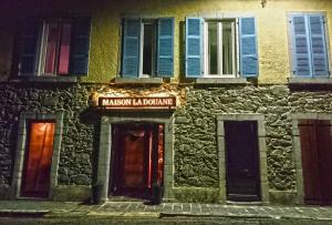 a building with a sign that reads malcolm islandalling at Maison La Douane - Comprends nettoyage professionnel et le linge in Laruns