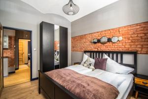 プラハにある3BDR RUTERRA Apt with Table Footballのレンガの壁のベッドルーム1室(大型ベッド1台付)