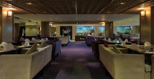 a dining room with tables and chairs in a restaurant at Davanam Sarovar Portico Suites in Bangalore