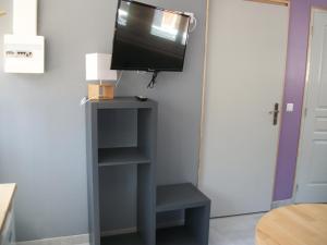 een tv op een plank in een kamer bij Les Mouettes 3 in Le Tréport