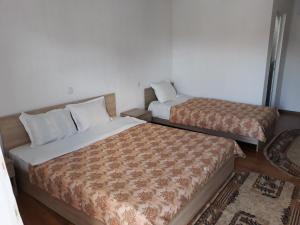 two beds sitting next to each other in a room at Вила Багрянови in Dospat