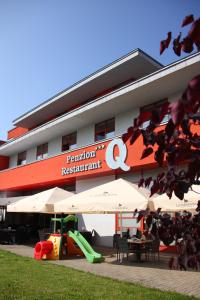 a building with a playground and tables and umbrellas at Penzión***Q in Zvolen