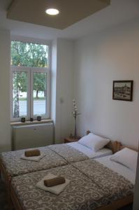 two beds in a bedroom with two towels on them at Apartmani Maja Zrenjanin in Zrenjanin