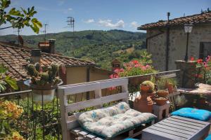 un banco sentado en la parte superior de un balcón con cactus en Authentic Chianti StoneHouse with Garden&Terrace, en Greve in Chianti