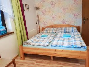 uma pequena cama com um cobertor xadrez em Apartments Helga em Bad Goisern