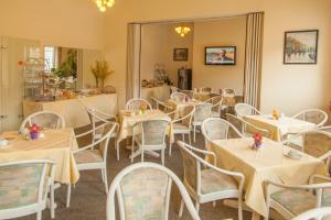 a dining room with white tables and white chairs at Hotel Moerser Hof in Moers