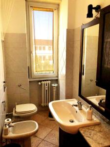 een badkamer met een wastafel, een toilet en een raam bij Porta Volta Flexyrent Studio in Milaan
