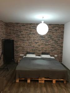 1 dormitorio con 1 cama grande y pared de ladrillo en Apartment Kubo, en Vranov nad Topľou