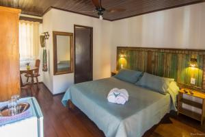 a bedroom with a bed with a towel on it at Pousada Portal in Tiradentes