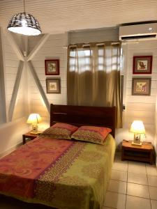 a bedroom with a bed and two lamps on tables at La Villa Des Tropiques - Turquoise in Les Trois-Îlets