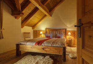 ein Schlafzimmer mit einem großen Bett und Holzdecke in der Unterkunft Chalets zum Ilsetal in Ilsenburg