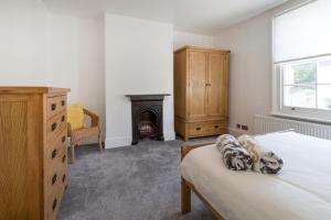 a bedroom with a bed and a dresser and a fireplace at Sleep & Stay Oxford - Oxford Town House in Oxford