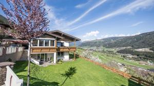 una casa con un giardino verde con un albero di Haus Auer Theresia a Telfes im Stubai