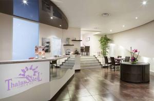 a restaurant with tables and chairs in a building at FAME - Marina baie des Anges in Villeneuve-Loubet