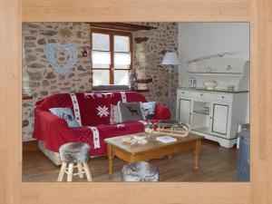 a living room with a red couch and a table at La Pouponiere in Sainte-Marie-aux-Mines