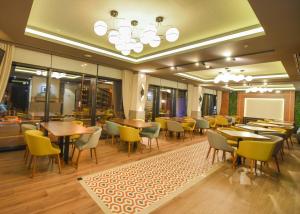 a restaurant with tables and chairs and a chalkboard at Hotel Union in Podgorica