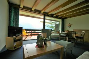 a living room with a television and a table with a couch at Alpenflair Ferienwohnung Whg 108 in Oberstdorf