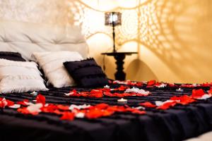 a bed with red flowers on top of it at b&b Casa Fusco in Fondi