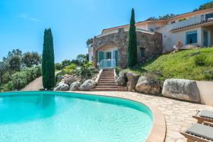 une grande piscine en face d'une maison dans l'établissement La Veglia, à Porto-Vecchio