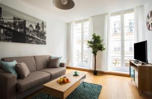 ein Wohnzimmer mit einem Sofa und einem Couchtisch in der Unterkunft Rue du Temple - Le Marais in Paris