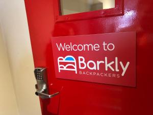 a sign on a red door with a welcome to barkley on it at Barkly Backpackers in Melbourne