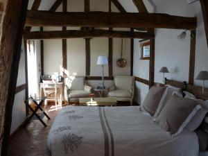 a bedroom with a bed and a living room at L'Etape Normande in Montroty