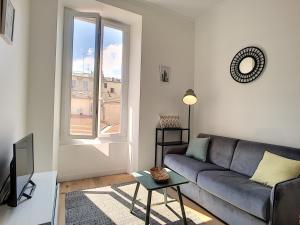 a living room with a couch and a window at Nestor&Jeeves - CAESARS - Hyper center - Shopping avenue in Nice