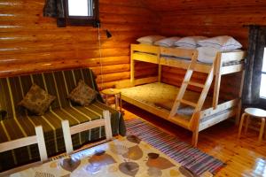 sypialnia z 2 łóżkami piętrowymi w drewnianym domku w obiekcie Laahtanen camping w mieście Ristijärvi