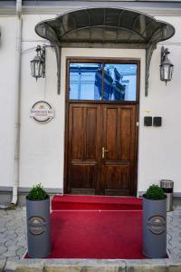 a wooden door with two potted plants in front of it at Bucharest Downtown Inn in Bucharest