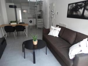 salon z kanapą i stołem w obiekcie Málaga Apartamentos - Jinetes, 10 w Maladze