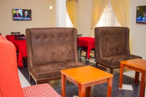 阿奴古Residency Hotels Enugu Independence Layout的两张皮椅和一张带红色桌布的桌子
