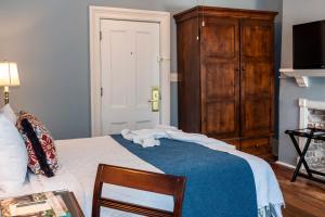 a bedroom with a bed with a blue blanket at The Marshall House, Historic Inns of Savannah Collection in Savannah