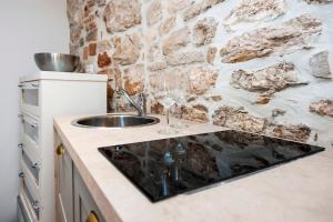 cocina con fregadero y pared de piedra en Apartment and Studio CA’ 3 VIE, en Rovinj