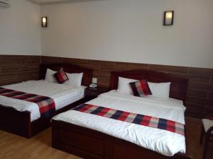 富國的住宿－Tan Hoang Gia Hotel，一间卧室配有两张带红色和黑色拼盘床单的床