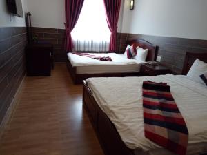 a hotel room with two beds and a window at Tan Hoang Gia Hotel in Phu Quoc