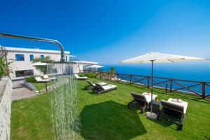 a backyard with a water fountain and chairs and an umbrella at Villa Paradise Resort in Agerola