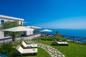 a house with two lawn chairs and an umbrella at Villa Paradise Resort in Agerola