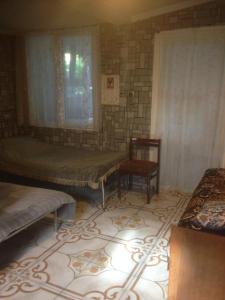 Zimmer mit 2 Betten, einem Fenster und einem Stuhl in der Unterkunft Gorgadze Apartment in Bordschomi