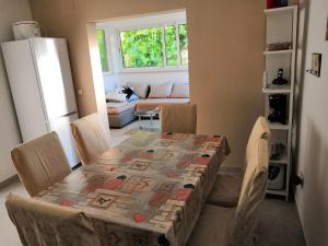 una mesa y sillas en una cocina con mesa y mantel en la parte superior en Apartments Mira, en Velike Kuknjare