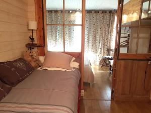 Un dormitorio con una cama con un osito de peluche junto a una ventana en Appartement chalet PRA LOUP 1600 La sapinière en Pra-Loup