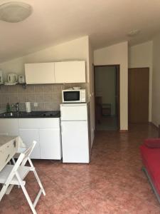 a kitchen with a white refrigerator and a microwave at Apartmani Šehović in Borovići