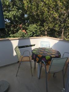 eine Terrasse mit einem Tisch, Stühlen und Bäumen in der Unterkunft Apartmani Šehović in Borovići