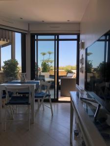 a living room with a table and chairs and a balcony at On the Beach in Lacanau-Océan