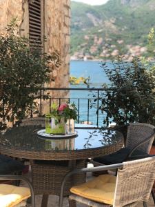 a table on a balcony with a view of the water at Oldhouse Vucinovic in Tivat