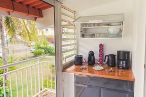 a kitchen with a counter and a balcony at Caribbean Appart' in Le Moule